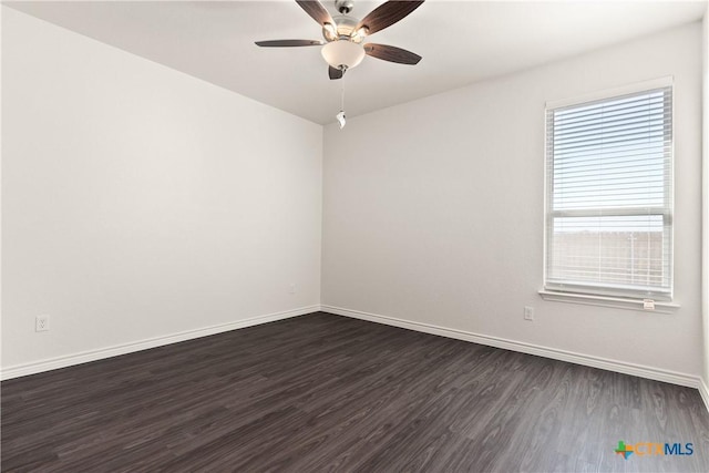 spare room with ceiling fan, baseboards, and dark wood finished floors