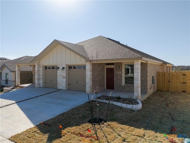 view of front of house featuring fence, driveway, an attached garage, board and batten siding, and brick siding