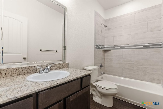 bathroom with bathtub / shower combination, vanity, toilet, and wood finished floors