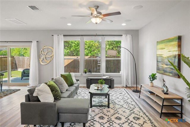 15806 Celosia St, Austin, TX 78728 - living area with visible vents, a ceiling fan, wood finished floors, and a healthy amount of sunlight
