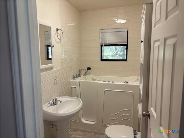 904 Deer Springs Dr, Burnet, TX 78611 - bathroom featuring a bath, toilet, and tile walls
