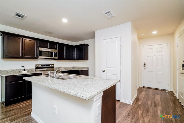 613 S 24th St, Temple, TX 76501 - kitchen featuring a sink, stainless steel appliances, a kitchen island with sink, visible vents, and dark wood-type flooring