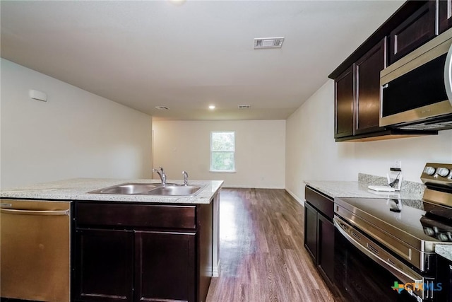 613 S 24th St, Temple, TX 76501 - kitchen with wood finished floors, a sink, visible vents, light countertops, and appliances with stainless steel finishes
