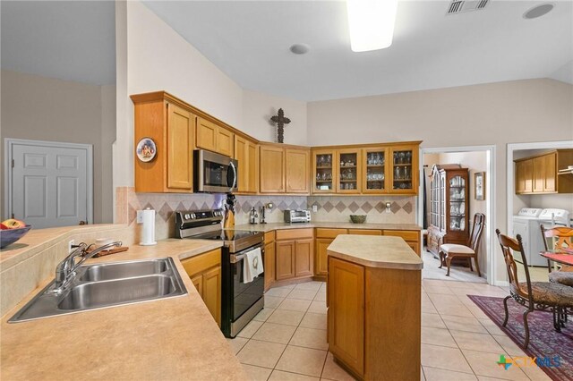 301 Deerchase, Victoria, TX 77901 - kitchen featuring independent washer and dryer, stainless steel appliances, a sink, lofted ceiling, and tasteful backsplash