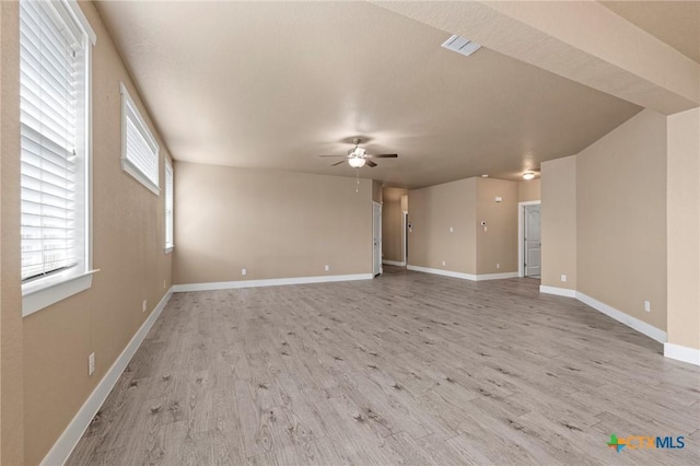 spare room featuring light wood finished floors, ceiling fan, visible vents, and baseboards