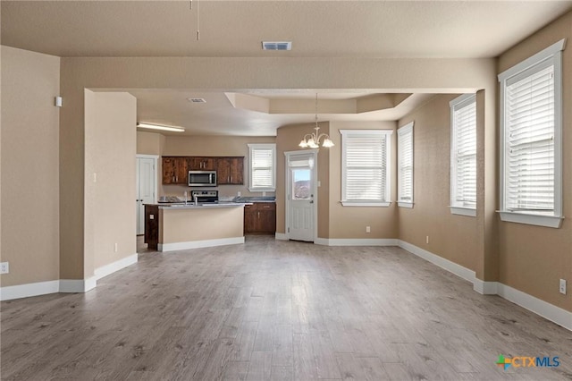 kitchen featuring open floor plan, stainless steel appliances, visible vents, and light wood-style floors