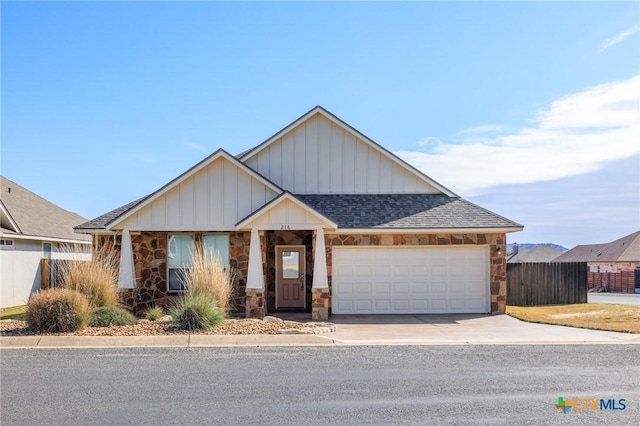 view of front of home featuring a shingled roof, concrete driveway, fence, a garage, and stone siding