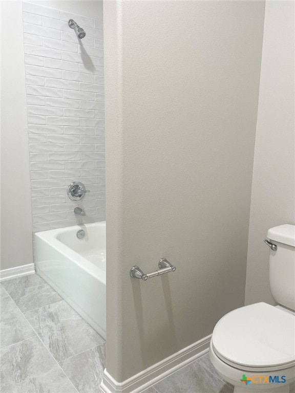 bathroom featuring tiled shower / bath and toilet