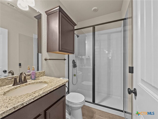 1306 Torino St, Harker Heights, TX 76548 - bathroom with toilet, a stall shower, vanity, and wood finished floors