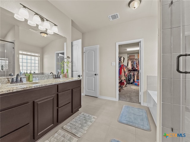 1306 Torino St, Harker Heights, TX 76548 - bathroom with a shower stall, double vanity, a spacious closet, a bath, and baseboards