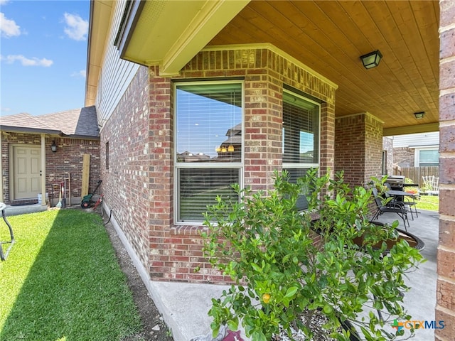 1306 Torino St, Harker Heights, TX 76548 - view of exterior entry with brick siding, roof with shingles, and a yard