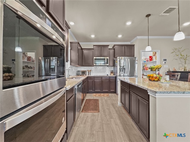 1306 Torino St, Harker Heights, TX 76548 - kitchen featuring appliances with stainless steel finishes, ornamental molding, a sink, dark brown cabinetry, and light wood-style flooring