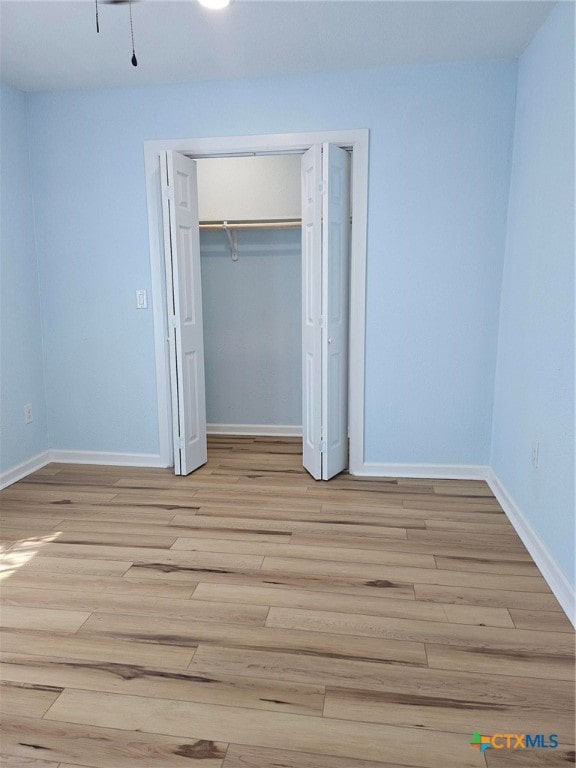 unfurnished bedroom featuring a closet and light hardwood / wood-style flooring