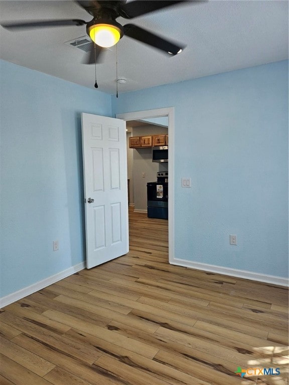 spare room featuring ceiling fan and light hardwood / wood-style flooring