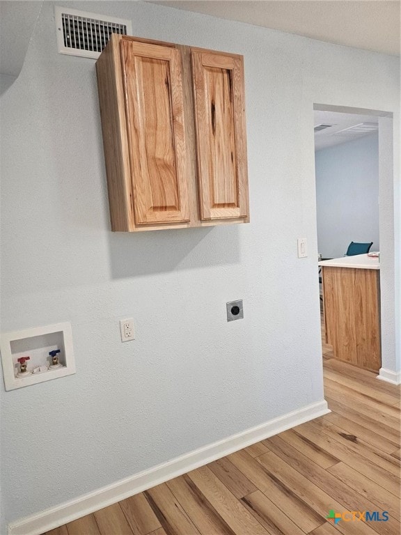 washroom featuring light wood-type flooring, cabinets, hookup for a washing machine, and hookup for an electric dryer