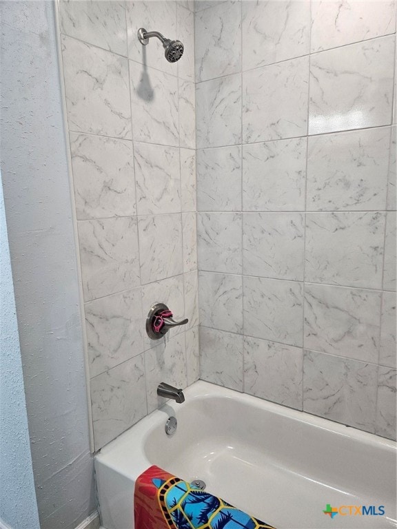 bathroom with tiled shower / bath combo