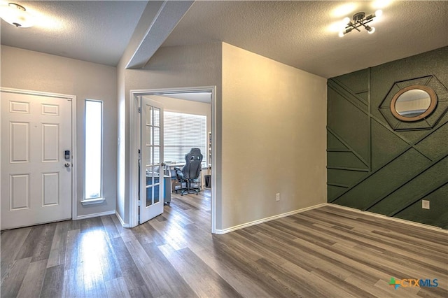 entryway with hardwood / wood-style floors and a textured ceiling