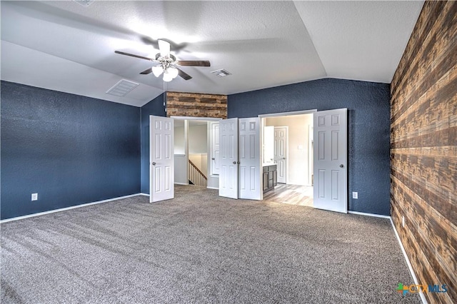 unfurnished bedroom with ceiling fan, carpet flooring, a textured ceiling, and lofted ceiling