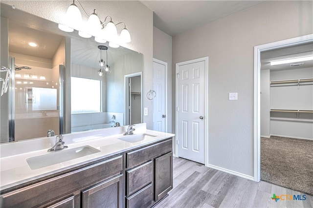 bathroom featuring wood-type flooring, vanity, and plus walk in shower