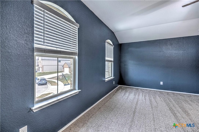 empty room with vaulted ceiling and carpet