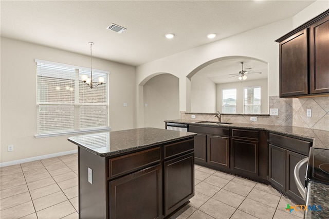 3411 Aubree Katherine Dr, Killeen, TX 76542 - kitchen with light tile patterned floors, arched walkways, dark brown cabinets, tasteful backsplash, and recessed lighting