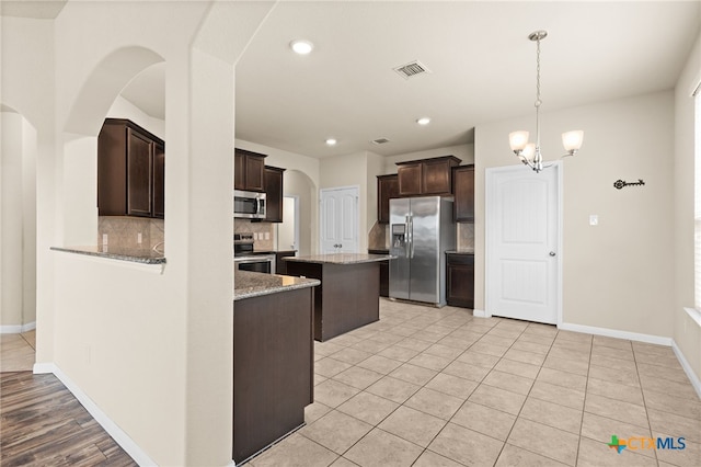 3411 Aubree Katherine Dr, Killeen, TX 76542 - kitchen featuring stainless steel appliances, backsplash, dark brown cabinetry, arched walkways, and recessed lighting