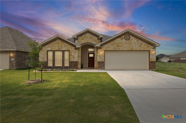 7109 Hammermill Ln, Temple, TX 76502 - view of front of home with a garage, concrete driveway, stone siding, a lawn, and brick siding
