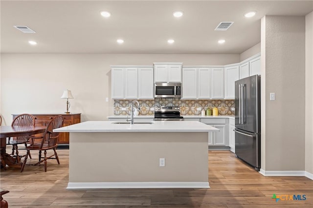 7109 Hammermill Ln, Temple, TX 76502 - kitchen with appliances with stainless steel finishes, light countertops, white cabinetry, decorative backsplash, and recessed lighting