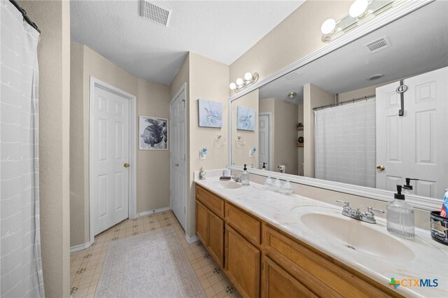 2903 Curtis Dr, Copperas Cove, TX 76522 - full bath with double vanity, tile patterned floors, and a shower with shower curtain