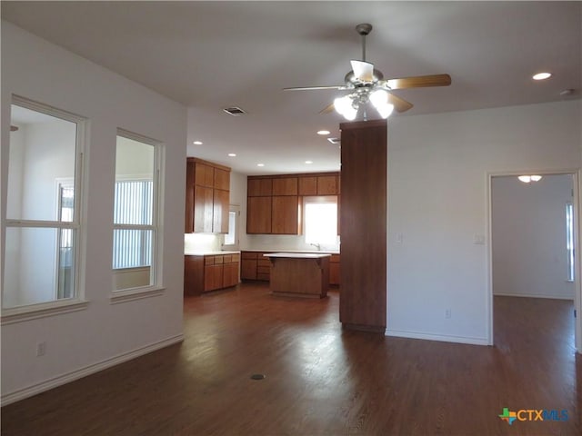 kitchen featuring ceiling fan, dark hardwood / wood-style floors, sink, and a kitchen island