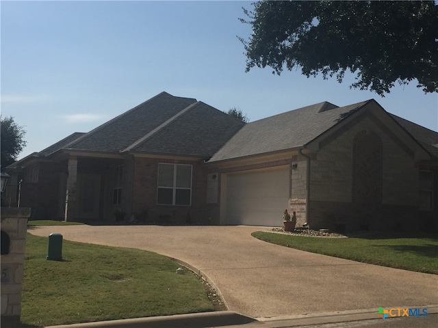 view of front of house with a garage and a front lawn