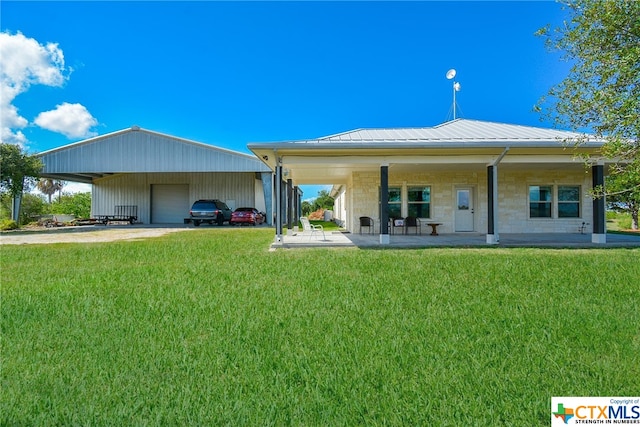 back of property with a lawn and a carport