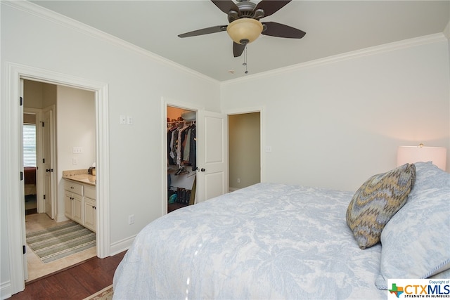 bedroom with a closet, a walk in closet, dark wood-type flooring, ceiling fan, and ensuite bathroom