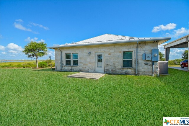 rear view of house featuring central AC unit, a patio, and a lawn