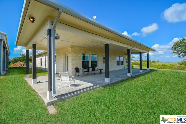 rear view of property with a lawn and a patio