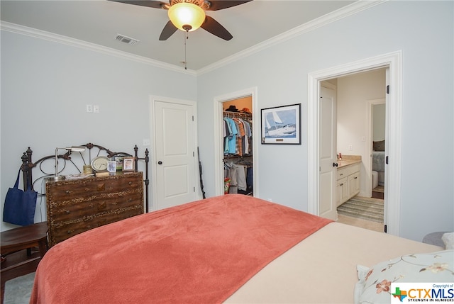 bedroom with ensuite bath, ceiling fan, crown molding, a closet, and a spacious closet