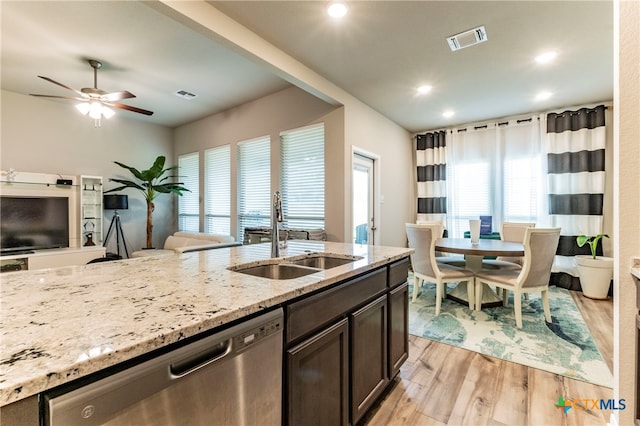 kitchen with light hardwood / wood-style floors, sink, stainless steel dishwasher, ceiling fan, and light stone countertops