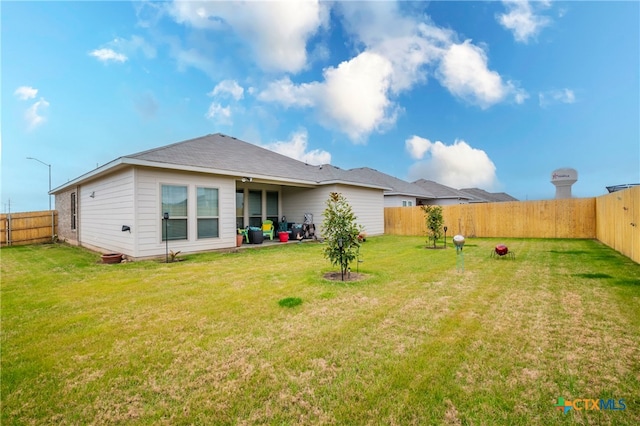 rear view of property with a yard and a patio