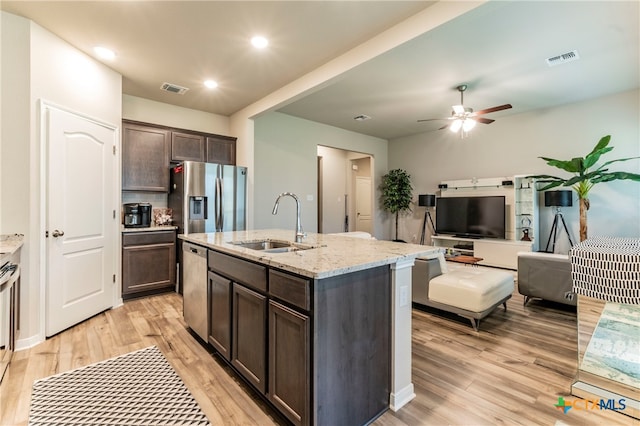 kitchen featuring appliances with stainless steel finishes, sink, dark brown cabinets, and light hardwood / wood-style flooring