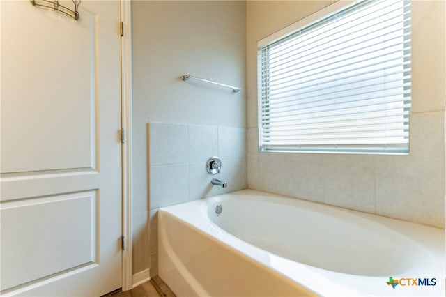 bathroom with a bathtub and a wealth of natural light