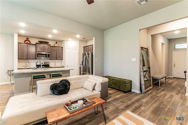 living room with dark hardwood / wood-style flooring and sink