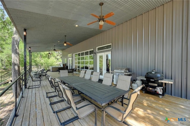 wooden terrace with grilling area, a ceiling fan, french doors, and outdoor dining space