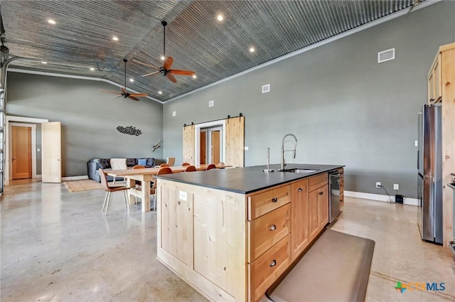 kitchen featuring stainless steel appliances, dark countertops, a ceiling fan, a sink, and concrete flooring