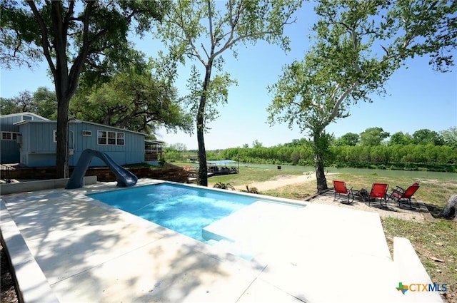 pool with a water slide and a patio