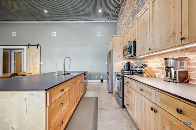 kitchen featuring light brown cabinets, dark countertops, a sink, finished concrete floors, and appliances with stainless steel finishes