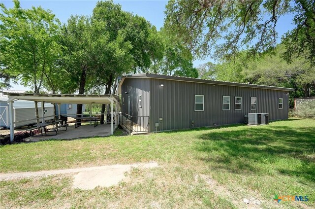 rear view of house featuring a yard, central AC unit, and a patio area