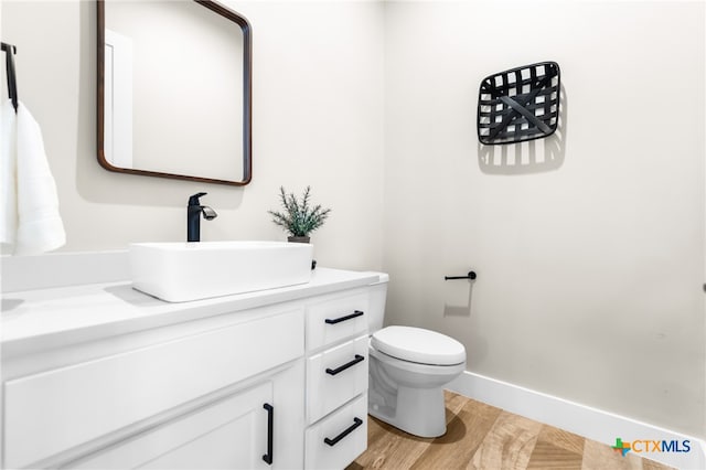 bathroom featuring hardwood / wood-style floors, vanity, and toilet