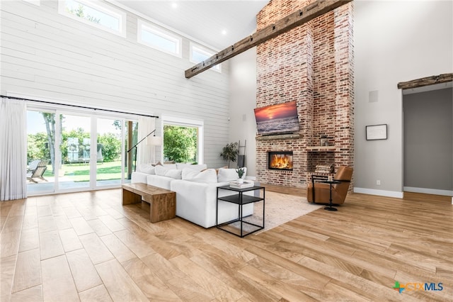 living room featuring light hardwood / wood-style flooring, a healthy amount of sunlight, and a high ceiling