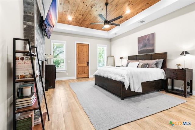 bedroom featuring wooden ceiling, ceiling fan, light hardwood / wood-style flooring, and a tray ceiling