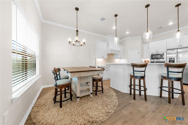 8917 Sassafras St, Temple, TX 76502 - dining room with ornamental molding, light wood-style floors, a chandelier, and baseboards